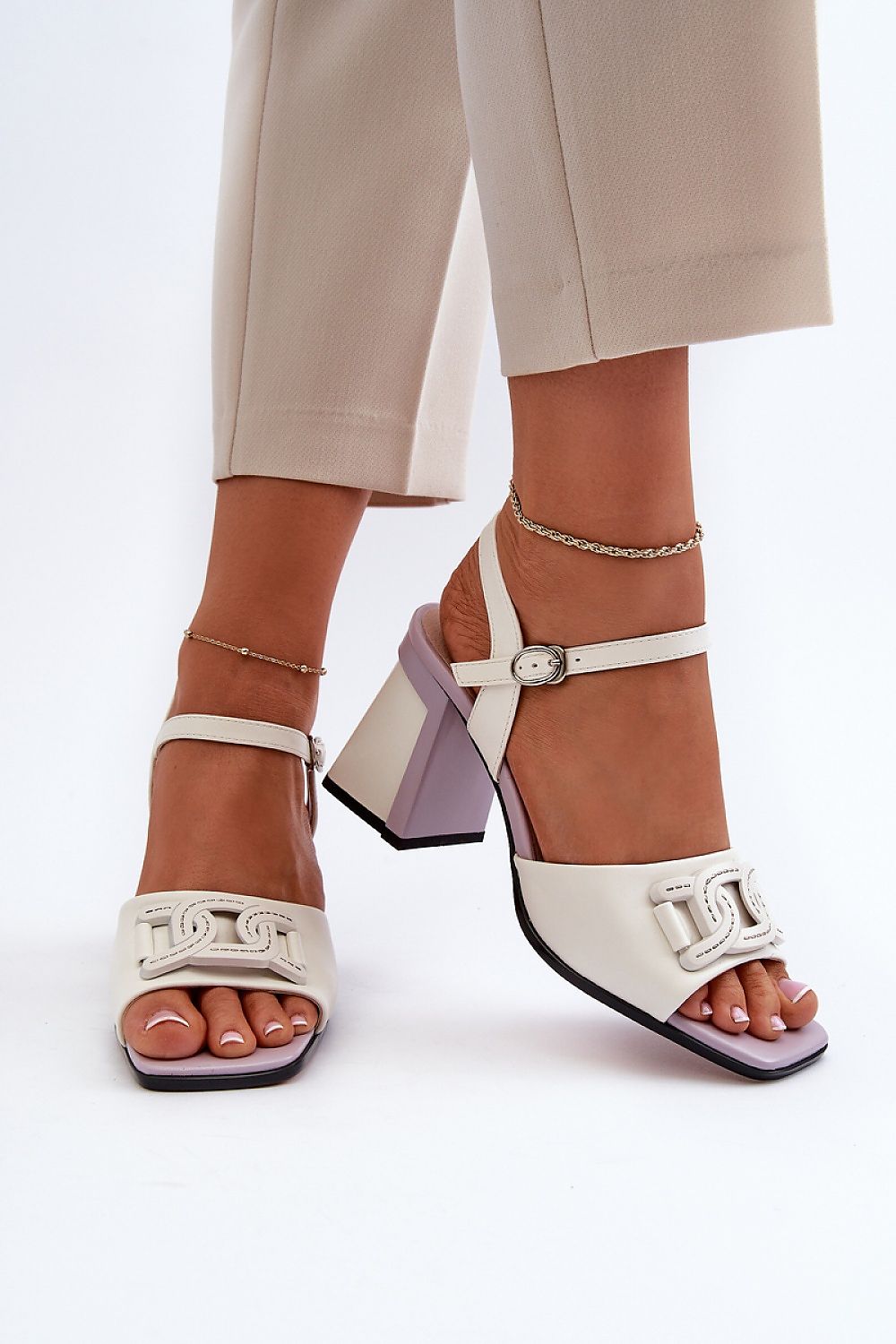 Stylish eco leather heeled sandals from Step in Style, featuring an adjustable strap and decorative front ornament, elegantly posed in a fashion-forward setting.
