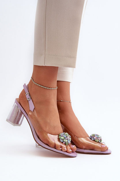 Stylish transparent stiletto sandals by Step in Style featuring a striking gem embellishment, set against a minimalist backdrop showcasing elegance and sophistication.