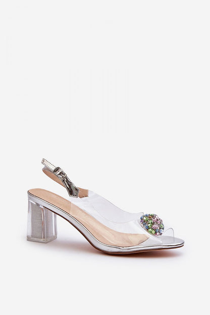 Refined clear heeled sandals by Step in Style with a delicate embellishment and adjustable strap, offering elegance and comfort for stylish ensembles.