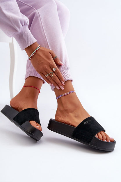 Big Star black suede leather flip-flops showcased elegantly on a model's feet, complemented by minimalist accessories and casual attire for a luxury summer look.