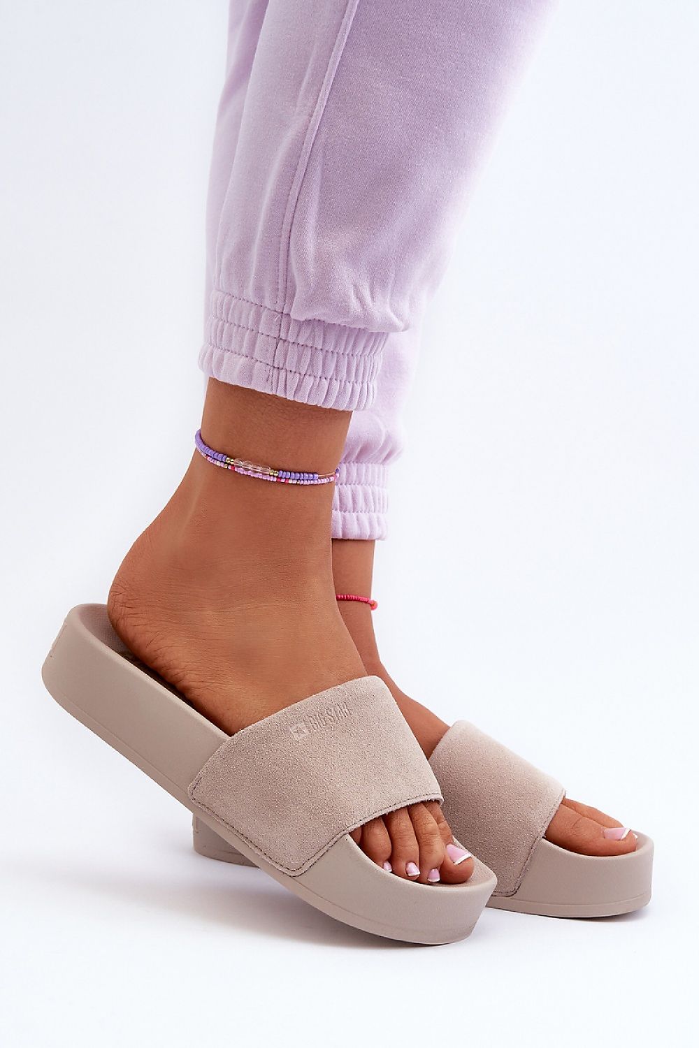 Chic beige suede leather flip-flops featuring a comfortable 4cm platform, elegantly worn by a model in light loungewear, ideal for luxurious summer strolls from Step in Style.