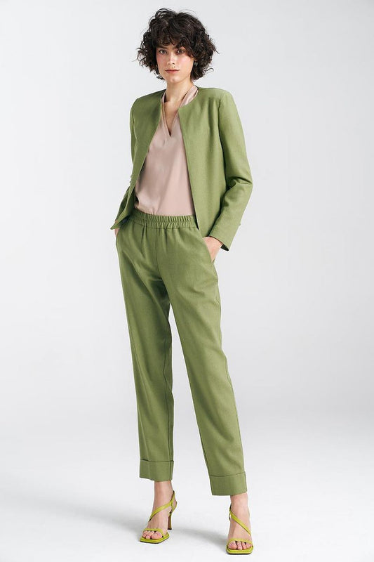 Chic model wearing a pistachio green boxy jacket by Nife paired with chic trousers, exuding a modern, stylish aura in a light and fresh atmosphere.