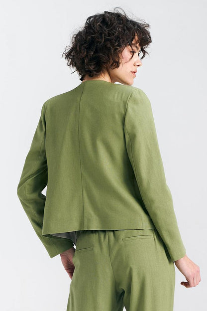 Back view of a pistachio green boxy jacket by Nife on a model with curly hair, highlighting its elegant silhouette and structured design.