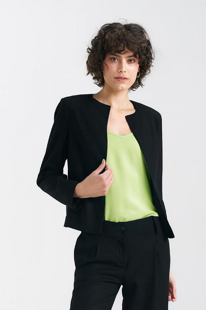 Elegant model showcasing a black boxy jacket paired with a light green top from Nife, combining sophistication and modern flair.