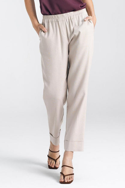 Elegant women's relaxed fit beige trousers with straight legs and cuffs by Nife, showcasing a comfortable elastic waistband and stylish pockets, perfect for sophisticated wear.