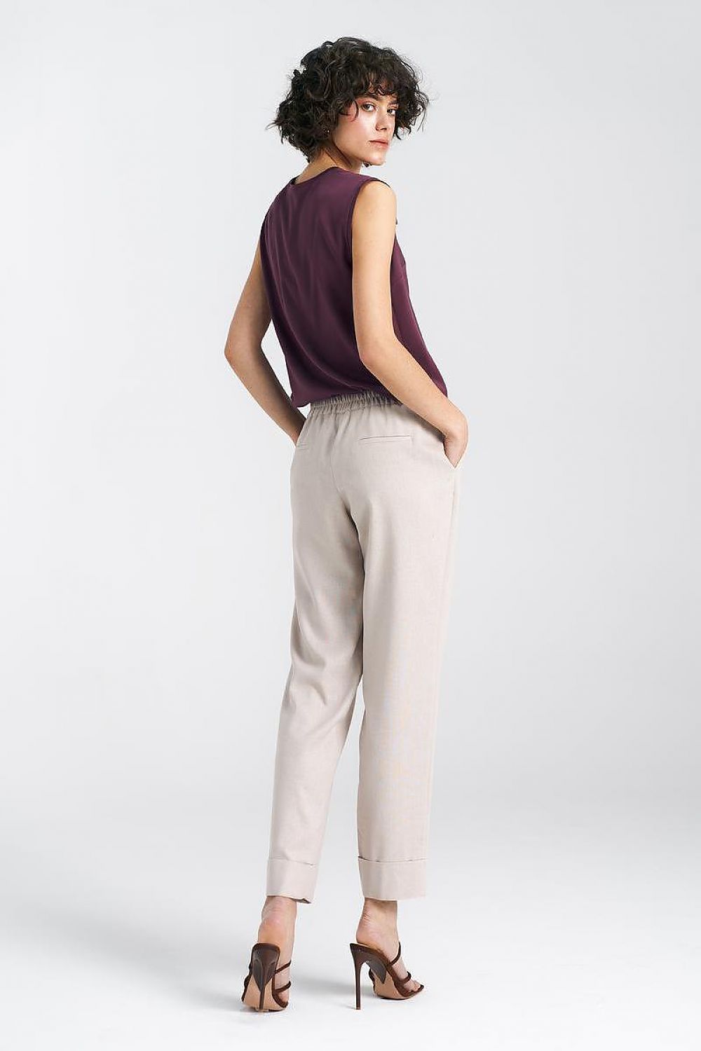 Elegant women's relaxed fit trousers with straight legs and cuffs by Nife, showcased with a stylish top, viewed from the back, perfect for sophisticated casual wear.