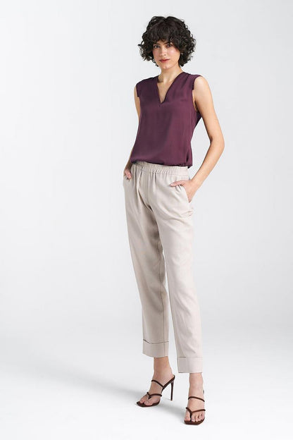 Front view of elegant women's relaxed fit trousers with straight legs and cuffs by Nife, paired with a chic top, ideal for refined everyday outfits.