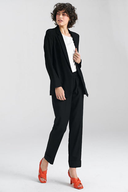 Sophisticated black trousers by Nife styled with a tailored blazer, exuding elegance in a modern professional look with striking orange heels.