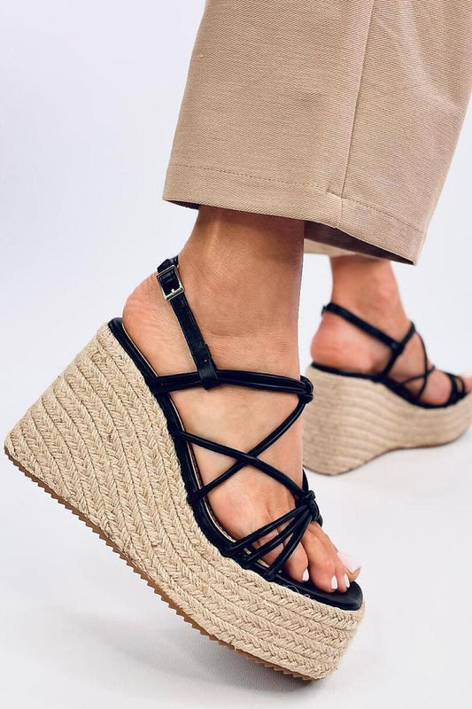 Chic close-up of Inello women's platform espadrilles sandals featuring an 11cm heel and intricate crossing straps, showcased on a model wearing tailored trousers, highlighting luxurious style and comfort.