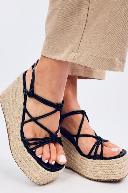 Sophisticated angled view of Inello women’s black espadrilles sandals on an 11cm heel, emphasizing the chic cross straps and eco-friendly construction, ideal for a luxurious fashion statement.