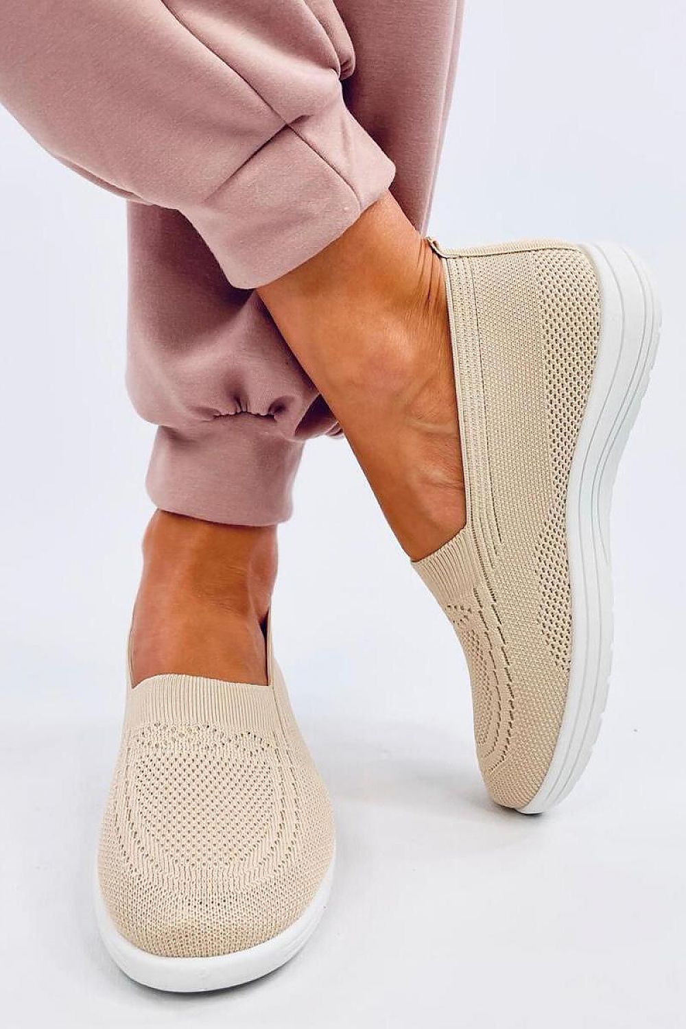 Elegant Inello women's slip-on sneakers featuring a springy sole, showcased on a model wearing stylish pink joggers. Perfect for comfort on warm days.