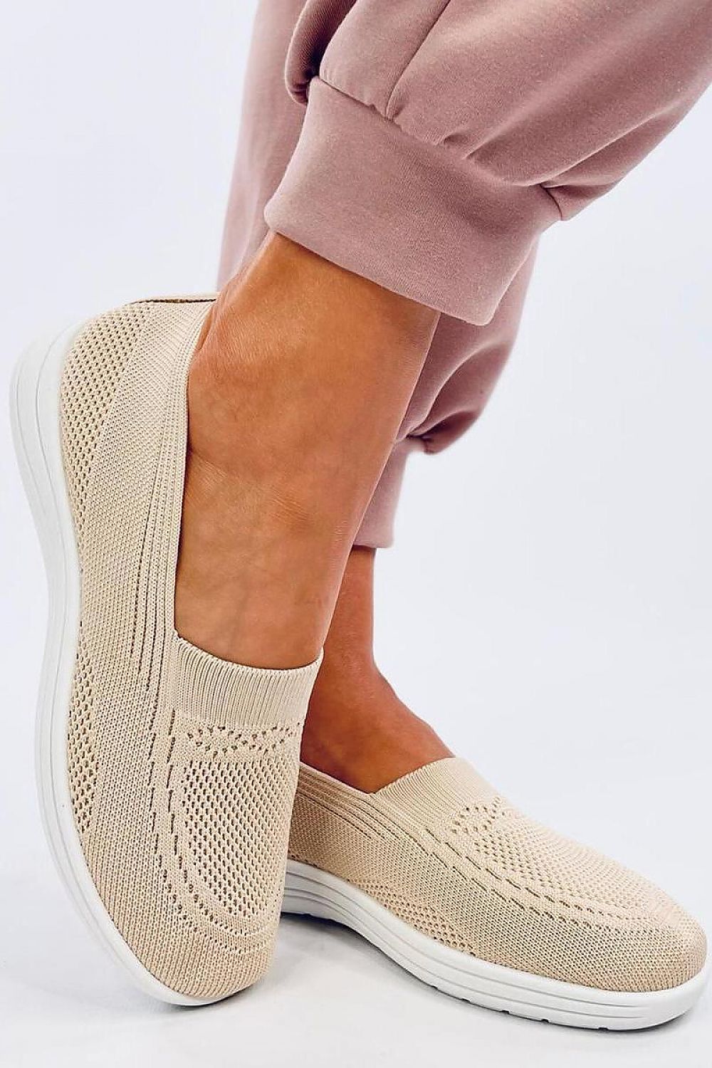 Chic Inello women's slip-on sneakers in a refined beige colour, presented on a model in trendy pink joggers, exemplifying stylish comfort for hot weather.