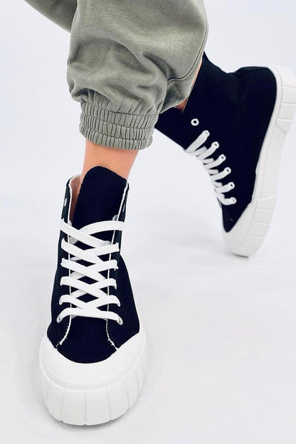 Stylish women's black canvas ankle sneakers by Inello, featuring a thick white sole, captured in a modern setting. Perfect for adding a fashionable touch to your outfit.