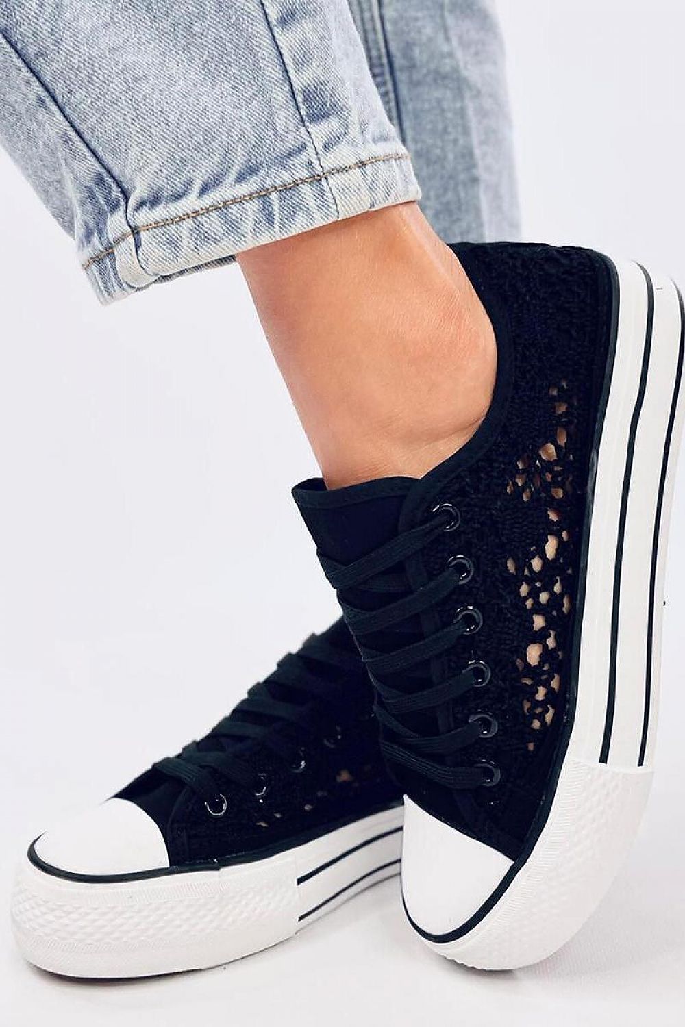 Sophisticated Inello black lace-up sneakers with intricate fabric design and contrasting white sole, expertly paired with casual denim for a chic ensemble.