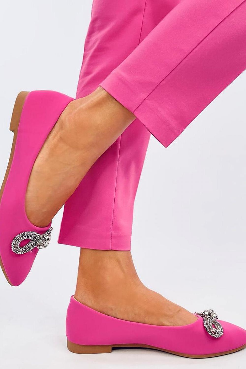 Chic pink Inello ballerina flats with a decorative zircon bow, perfectly accentuating a fashionable outfit, ideal for stylish occasions.