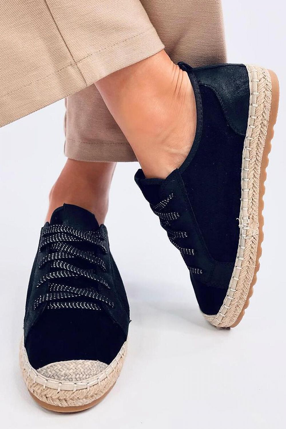 Side view of Inello women's espadrille sneakers featuring a braided sole and shimmering laces, styled elegantly on a model, embodying luxury and comfort.