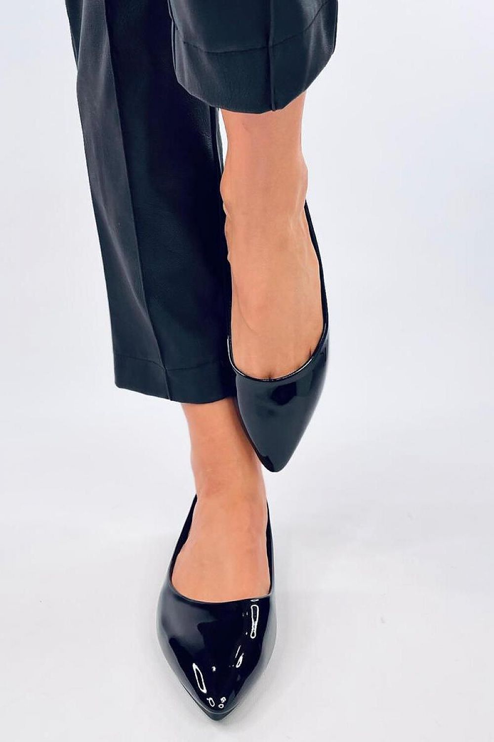 Elegant Inello patent leather ballet flats showcased on a woman's foot, featuring a graceful almond toe design, perfect for sophisticated dressing.