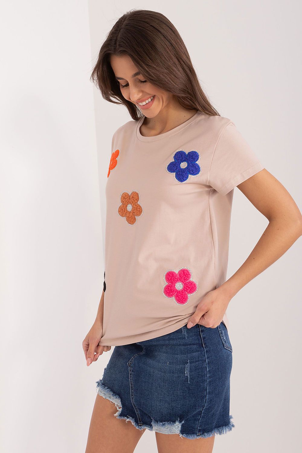 Charming floral decorated cotton blouse in soft beige style, perfect for summer, modelled by a woman, by BFG.