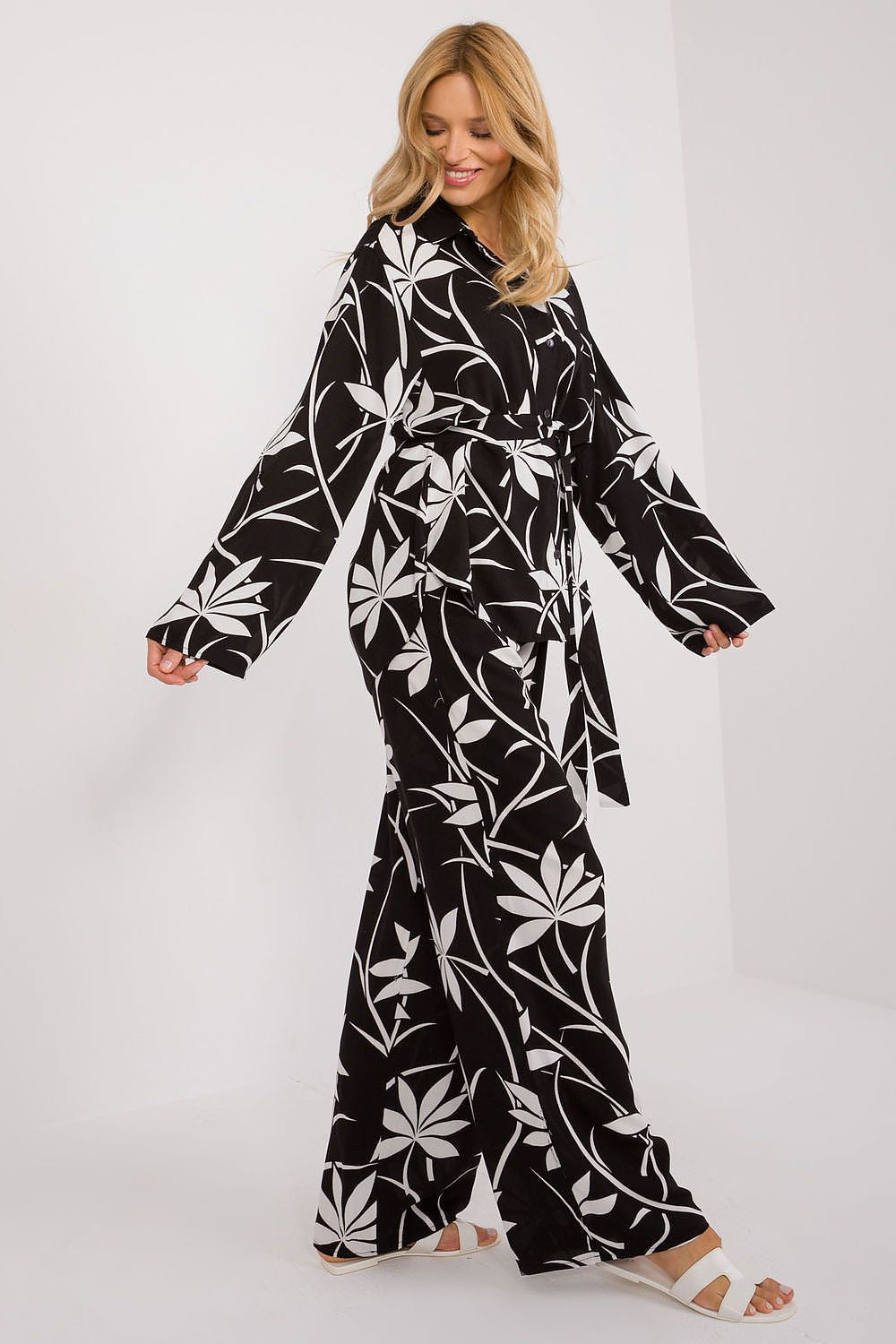 Chic Lakerta cotton casual set captured in motion, model wearing a black and white floral ensemble with a belted waist, epitomising relaxed elegance.