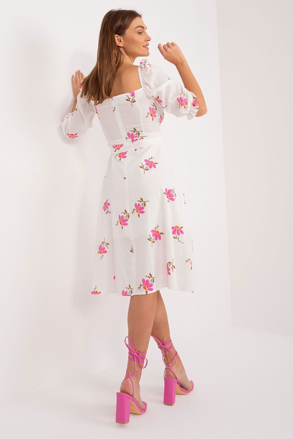 Back view of the Floral Midi Summer Dress by Lakerta, highlighting the stylish ruffle sleeves and delightful floral pattern, paired with elegant pink sandals.