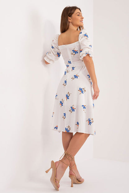 Fashion-forward floral midi summer dress by Lakerta, revealing a feminine back design with a flattering square neckline. Model showcases the beauty of the dress with elegant beige strappy heels.