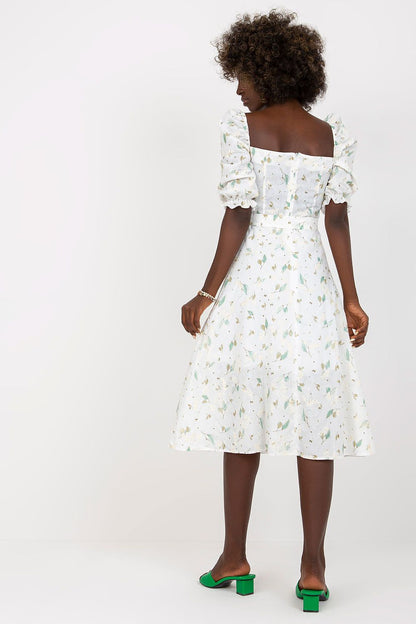 Back view of the Lakerta floral midi summer dress showcasing its beautiful lace detailing and ruffle sleeves, complemented by chic green block heeled sandals.