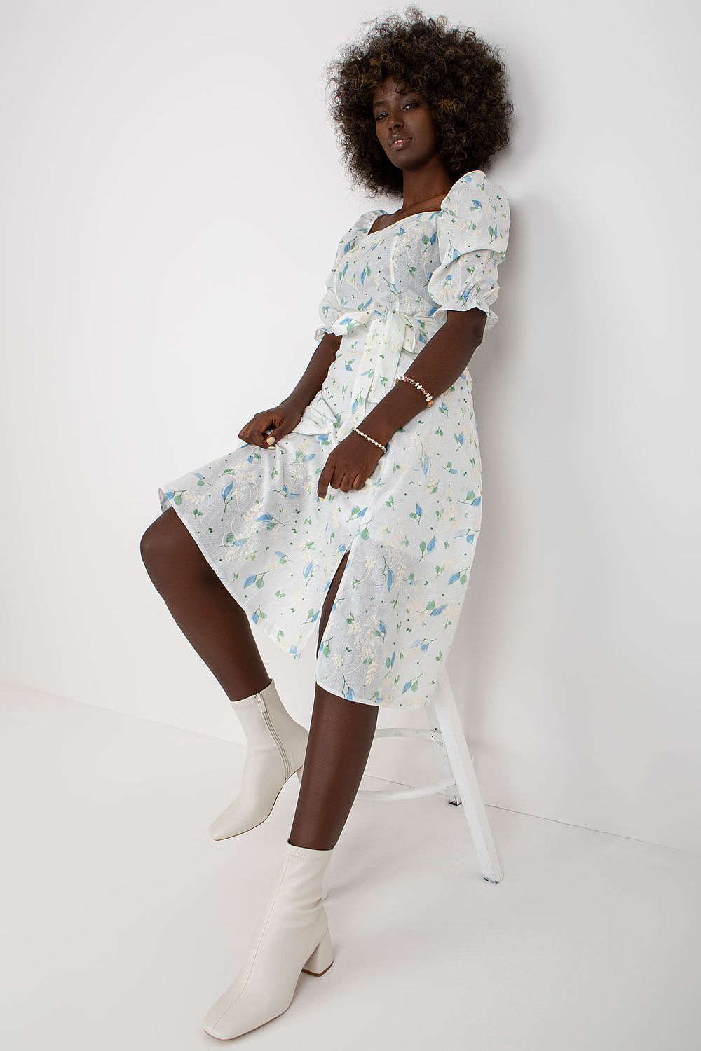 Close-up view of the Lakerta floral midi summer dress, featuring delicate flower prints and stylish side slit, paired with sophisticated white ankle boots.