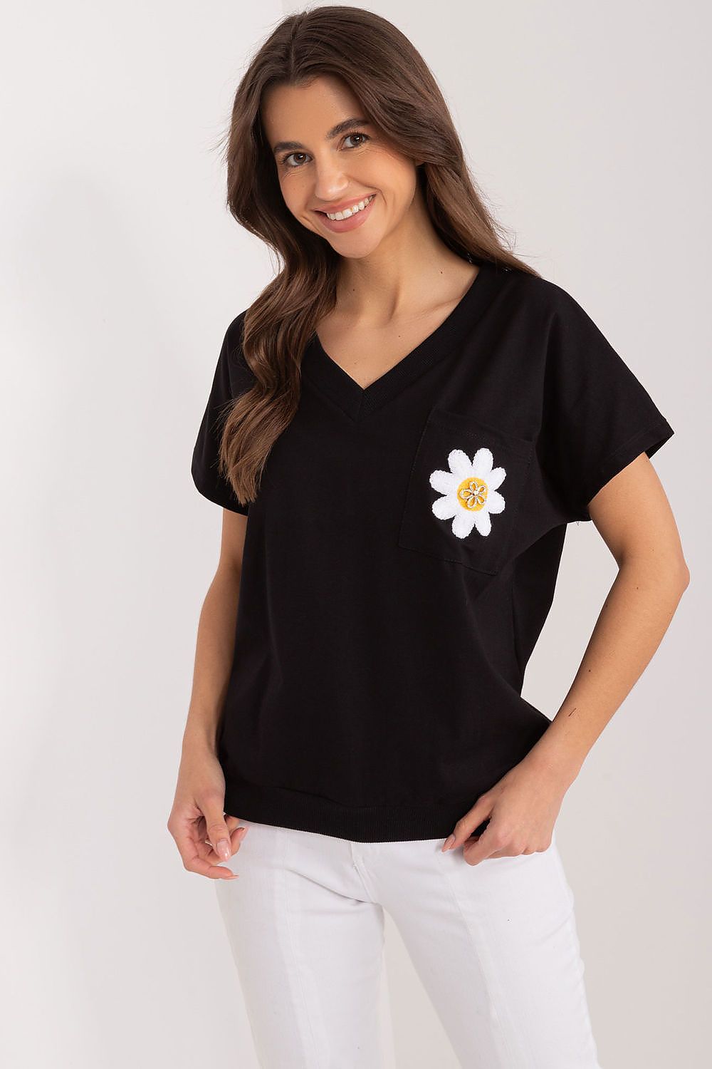 Chic black cotton blouse by Rue Paris, adorned with an embroidered flower pocket design, exuding luxury in a casual setting.
