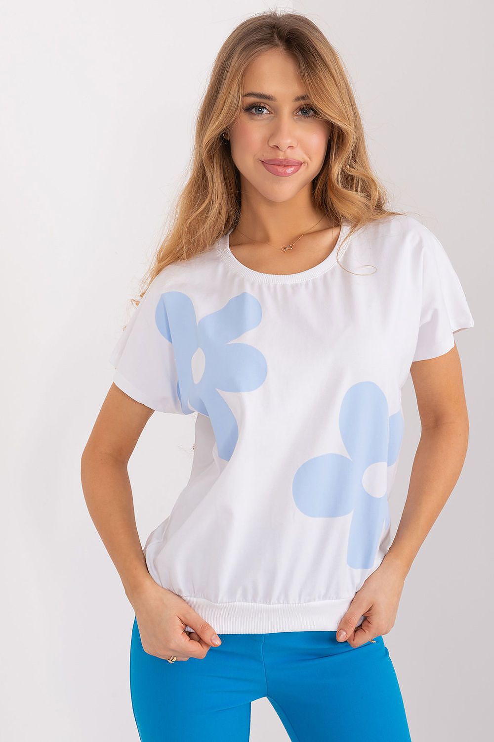 Elegant Rue Paris cotton blouse with blue floral design, featuring short sleeves and a round neckline, styled for a casual yet chic outfit.