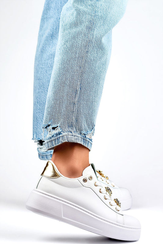 Close-up of PRIMO Women's White Eco-Friendly Sport Shoes featuring elegant gold accents, paired with distressed denim for a chic, sporty look.