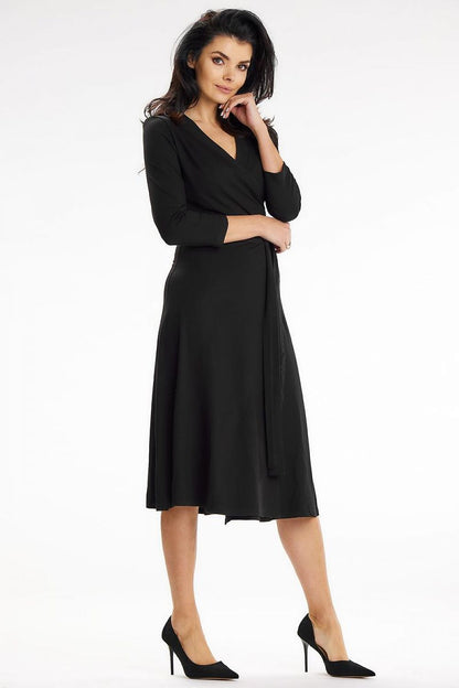 Sophisticated black midi dress by Awama featuring a fitted top, waist belt, and 3/4 sleeves, perfect for elegant occasions.