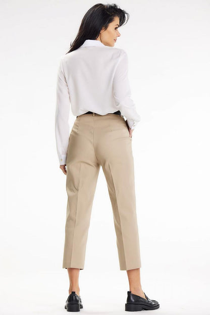 Back view of a woman in an elegant Awama long sleeve shirt, highlighting the refined design and fit, paired beautifully with stylish trousers.