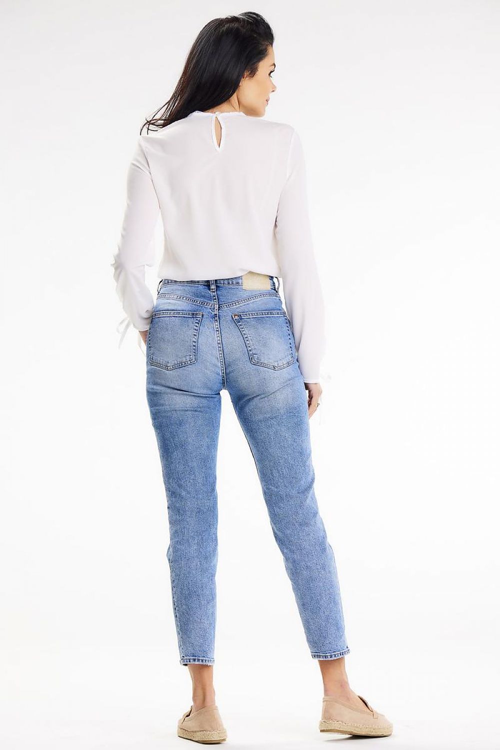 Back view of a woman in an Awama long-sleeve blouse and jeans, highlighting the button closure detail at the back, exuding sophistication.