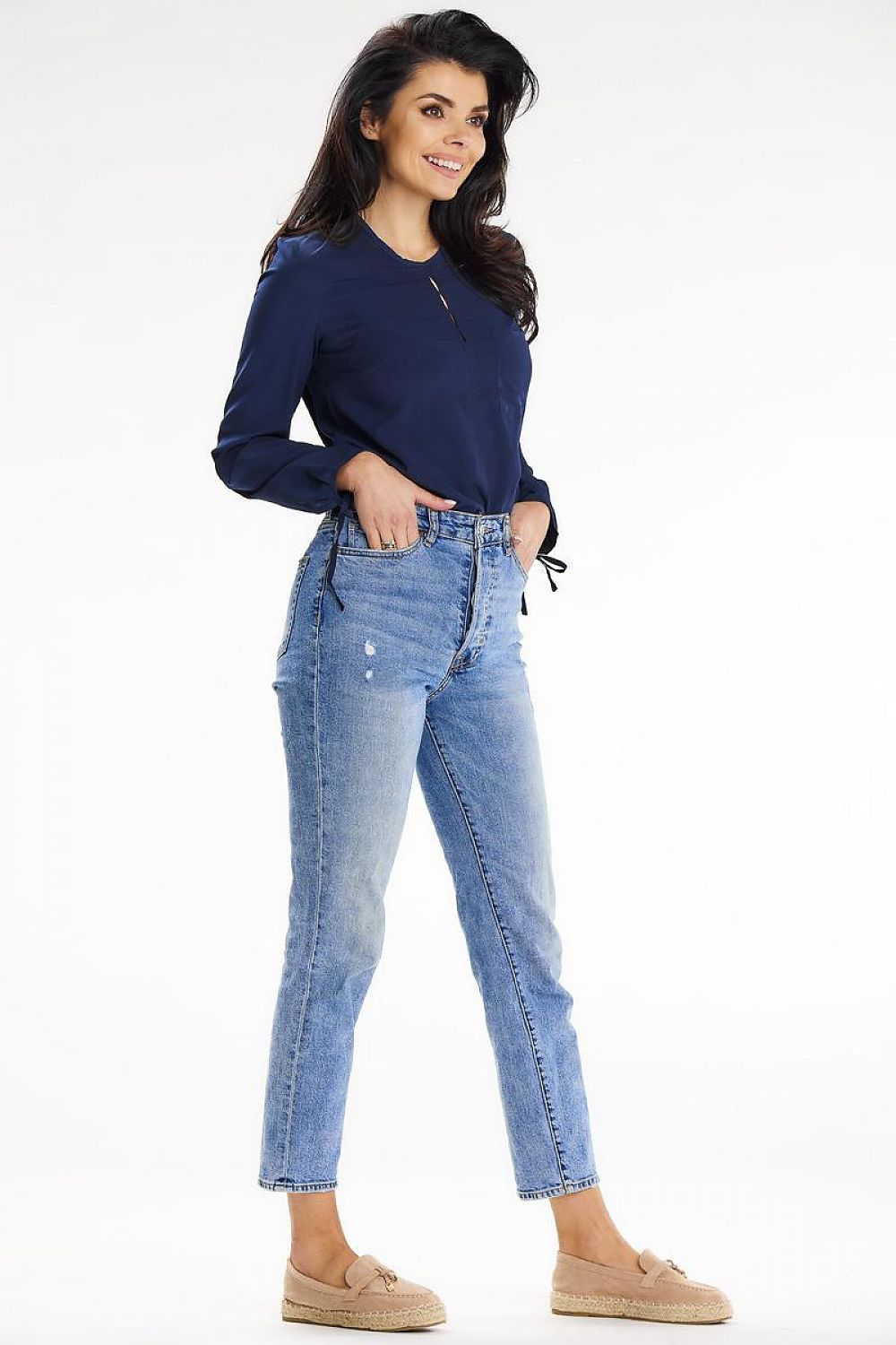 Woman posing confidently in a navy Awama shirt and high-waisted jeans, epitomising modern elegance and style for versatile occasions.