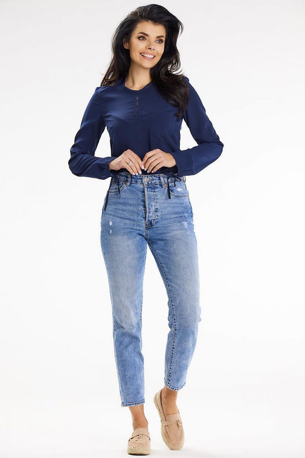 Front view of a model showcasing a sophisticated navy blouse with long sleeves and button detail, perfectly paired with light blue high-waisted jeans, designed by Awama.