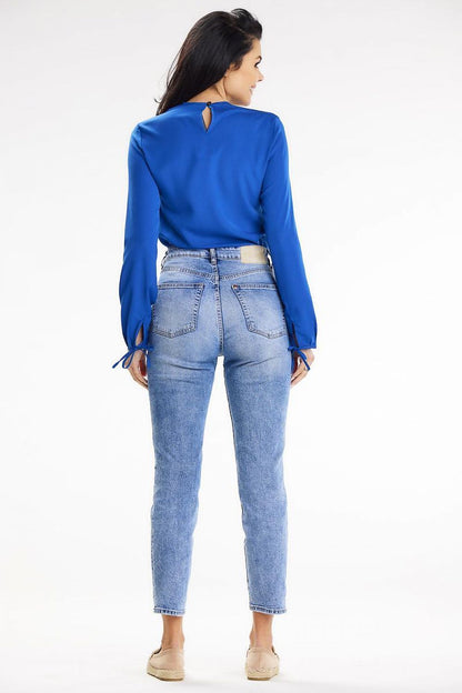 Back view of a model wearing a blue blouse featuring a button closure, crafted by Awama, paired with stylish high-waisted jeans, showcasing a contemporary silhouette.