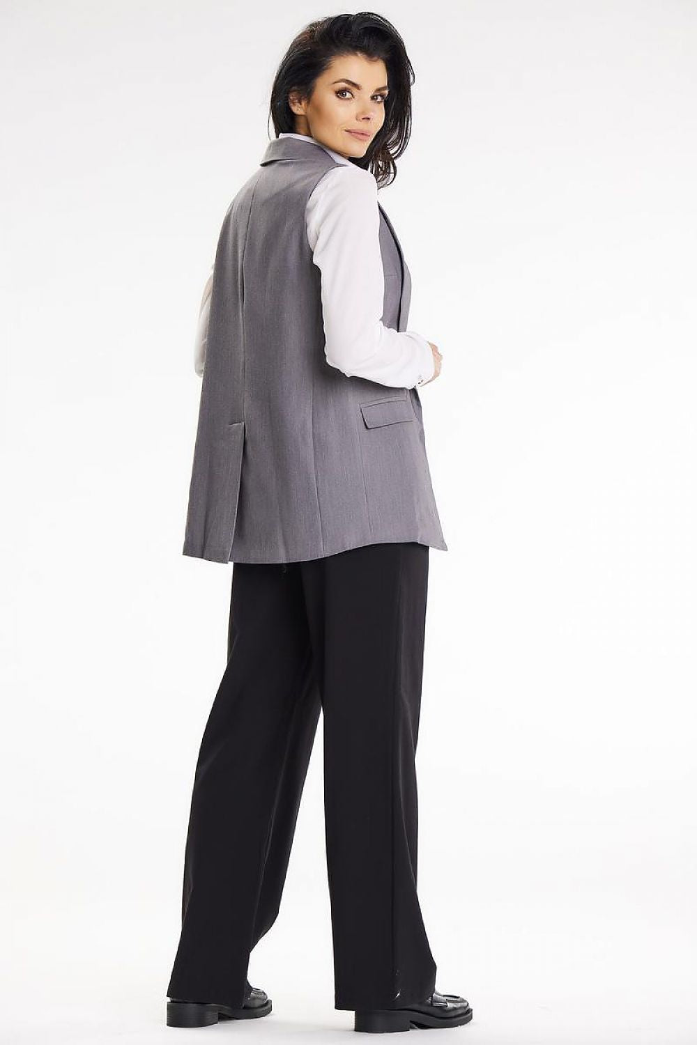 A woman wearing an elegant shawl collar vest by Awama, demonstrating a chic and professional look for business attire.