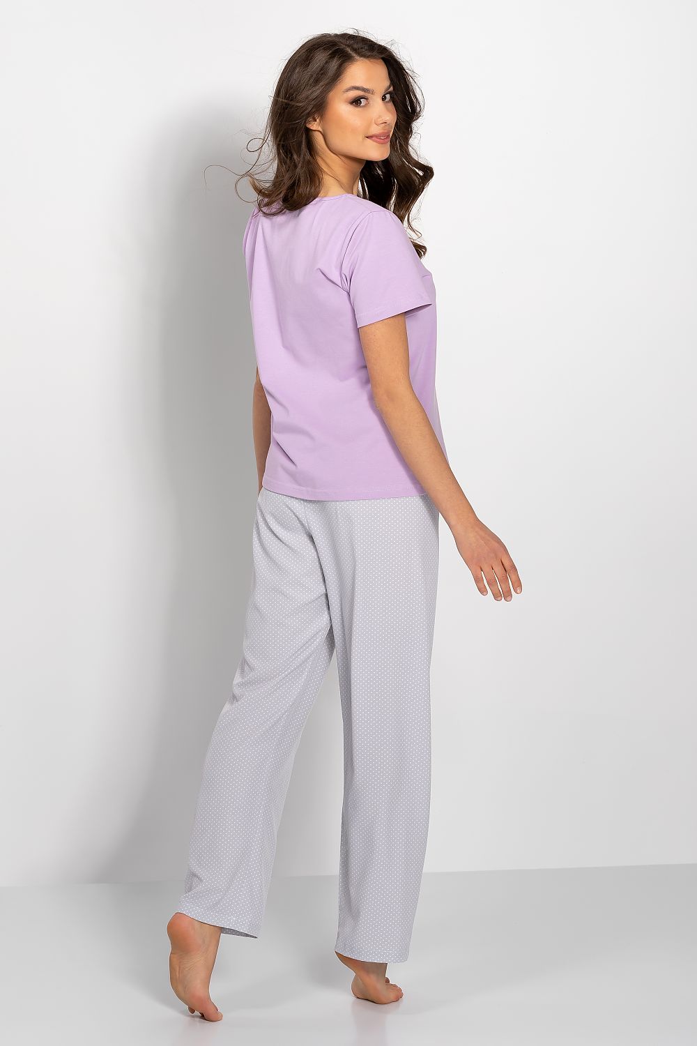Sophisticated back view of a women's luxury lilac pyjama set showcasing a short-sleeved blouse and polka dot long pants, ideal for upscale loungewear.