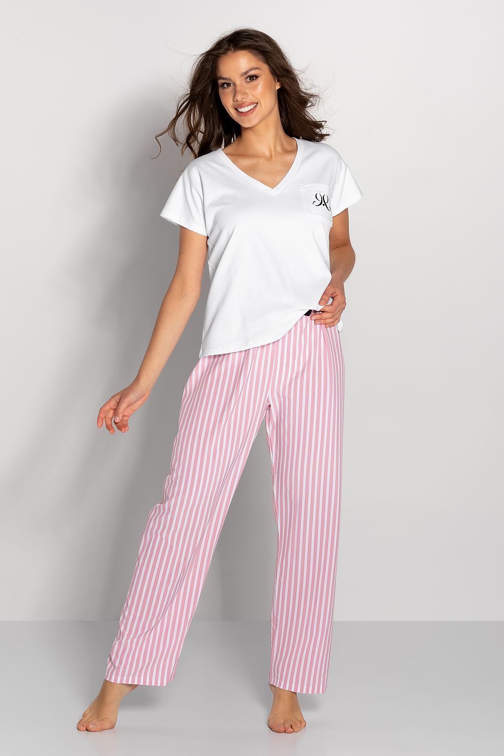 Model showcasing Luxury Ladies' Pyjamas Set with Short-Sleeved Blouse and Long Striped Pants - Elegant Comfort, featuring a short-sleeved white blouse with a pocket and pink striped long pants.