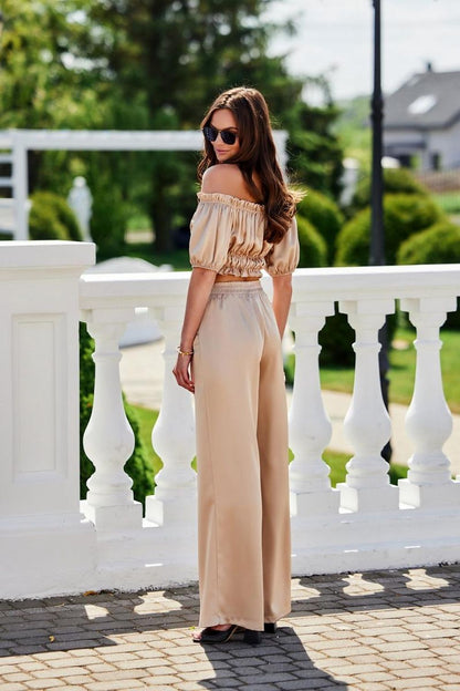 Model wearing the Marbella Satin Blouse by Roco Fashion at a garden party, demonstrating the blouse's suitability for elegant summer events.