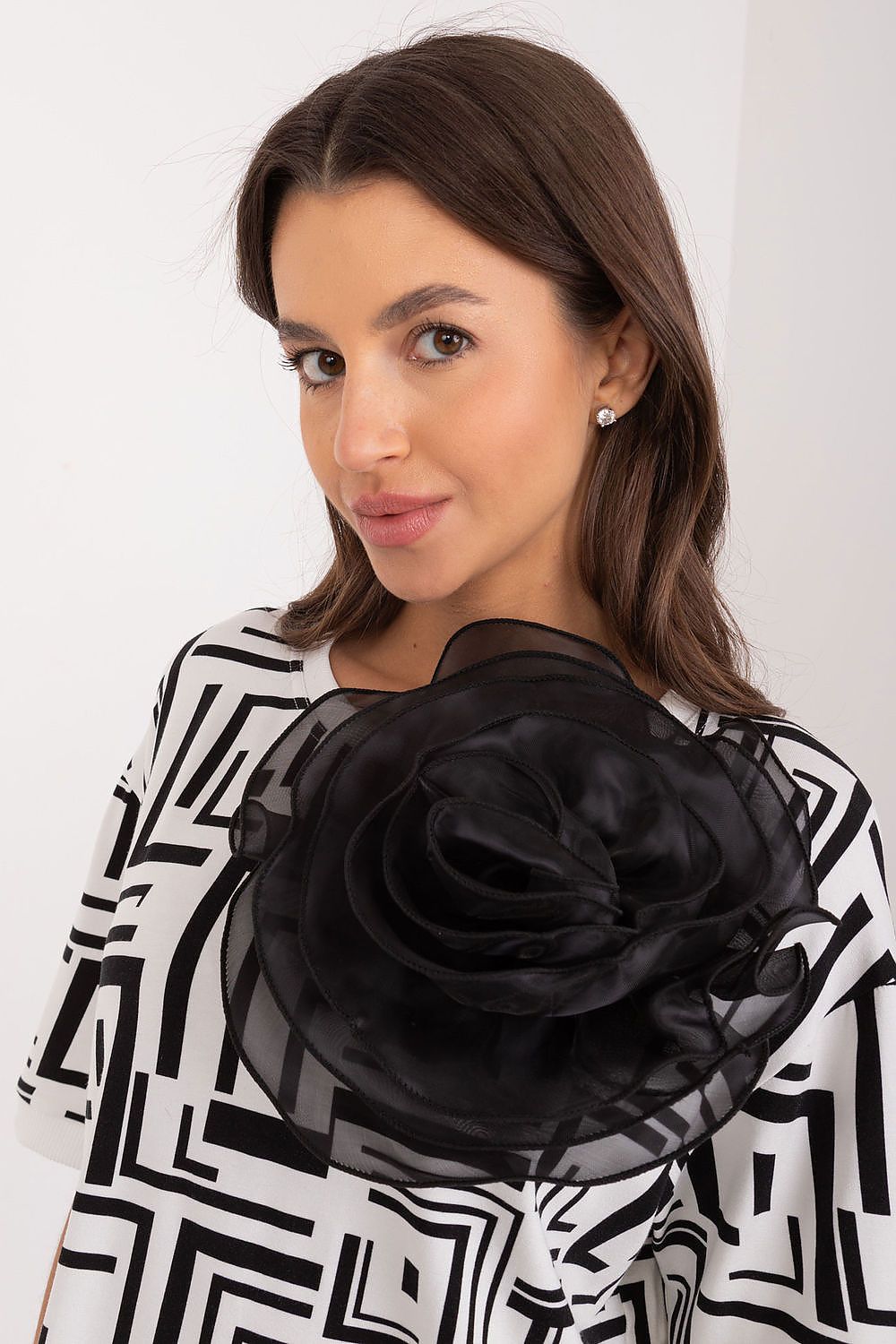 Close-up of Lakerta's stylish viscose blouse showcasing the fabric flower brooch and intricate geometric design, ideal for a luxurious everyday look.