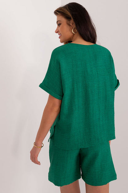 Sophisticated model wearing Lakerta's elegant v-neck shirt and high-waisted shorts ensemble, embodying contemporary summer fashion with a luxurious touch.