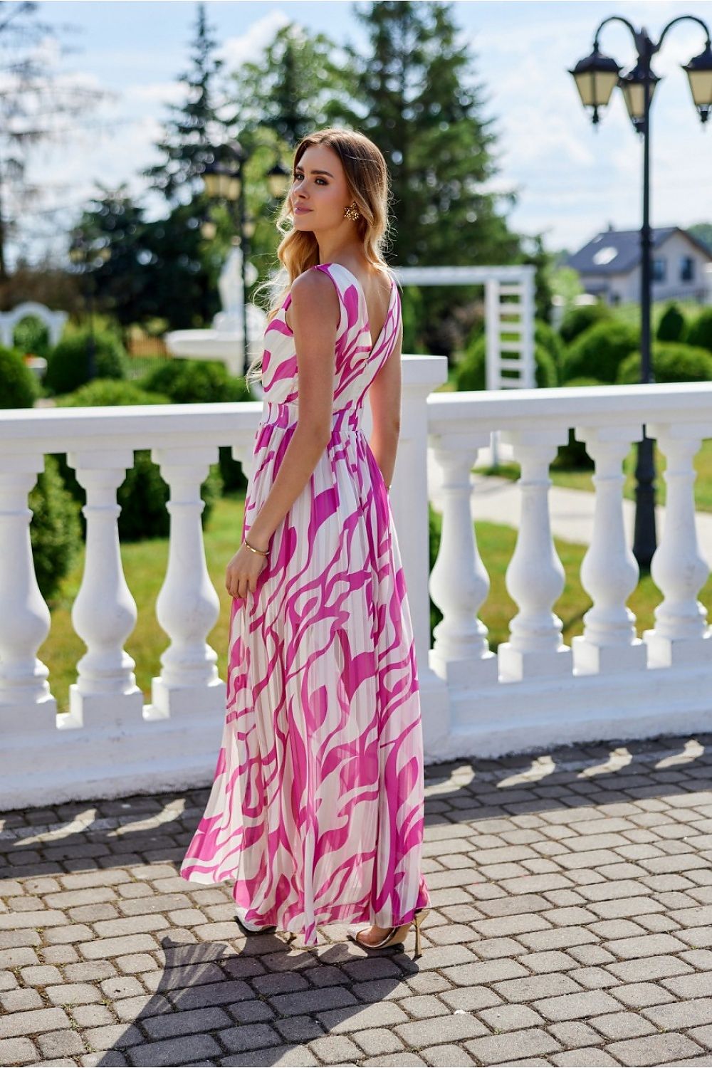 Full-body image of an elegant maxi chiffon dress by Roco Fashion, highlighting the delicate cutout back and flattering leg slit for any occasion.