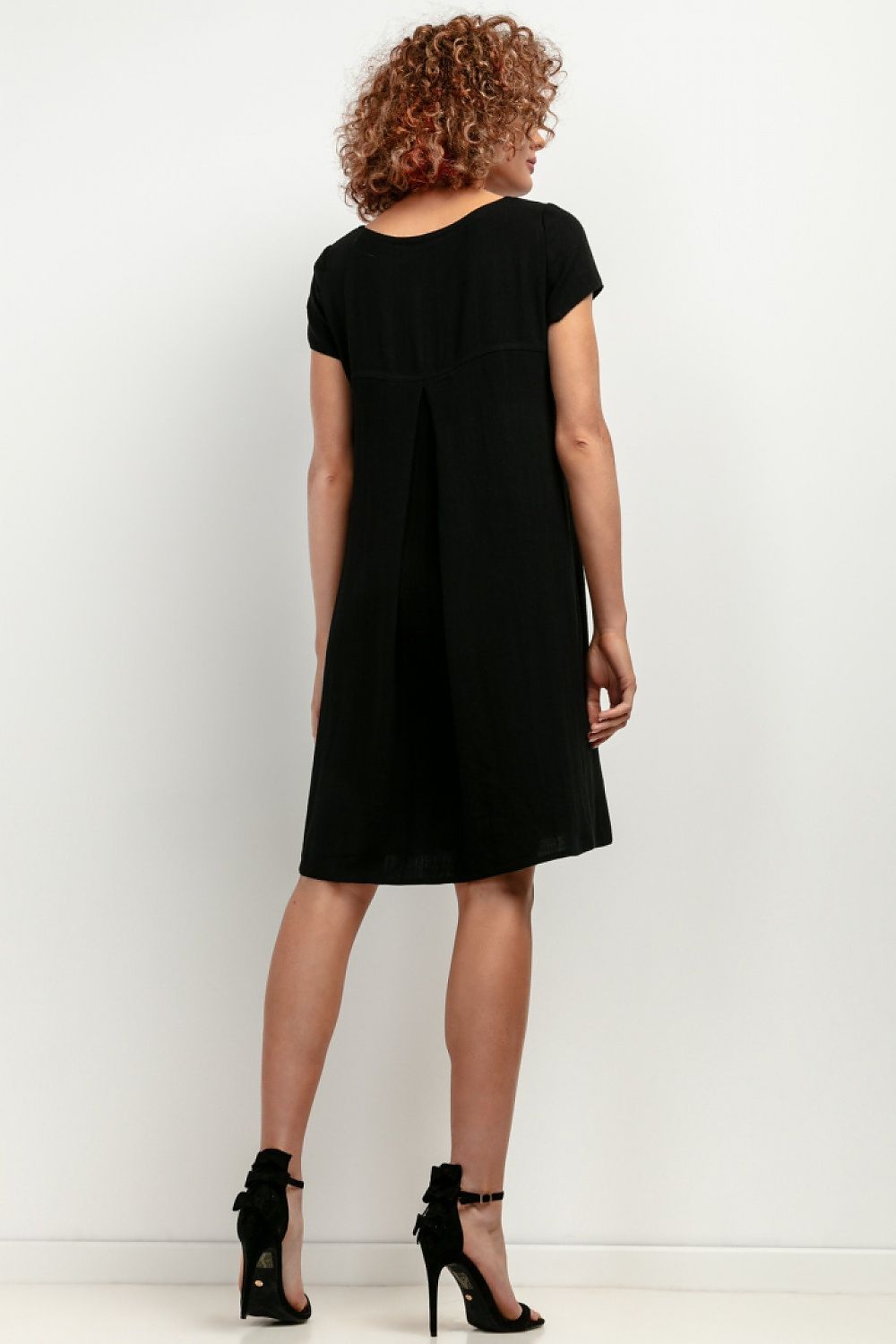 Model wearing the T403 linen dress by Tessita at a beach setting, exemplifying chic comfort and elegance for summer events.