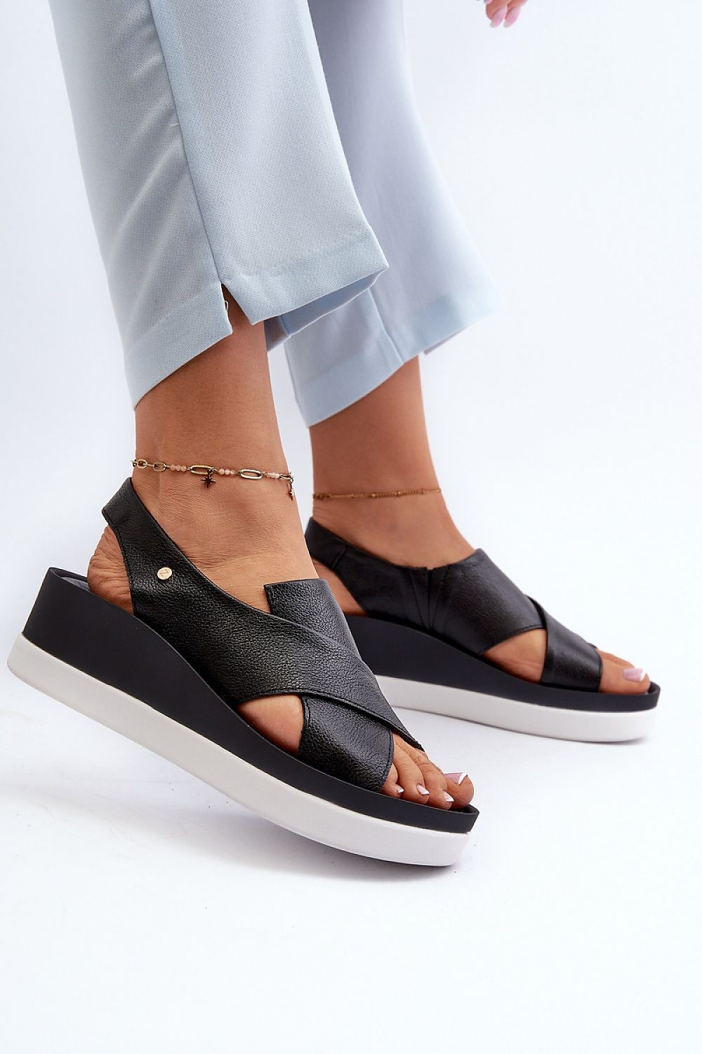 Elegant display of Step in Style luxury women's slip-on sandals, featuring a decorative emblem and a comfortable platform heel.