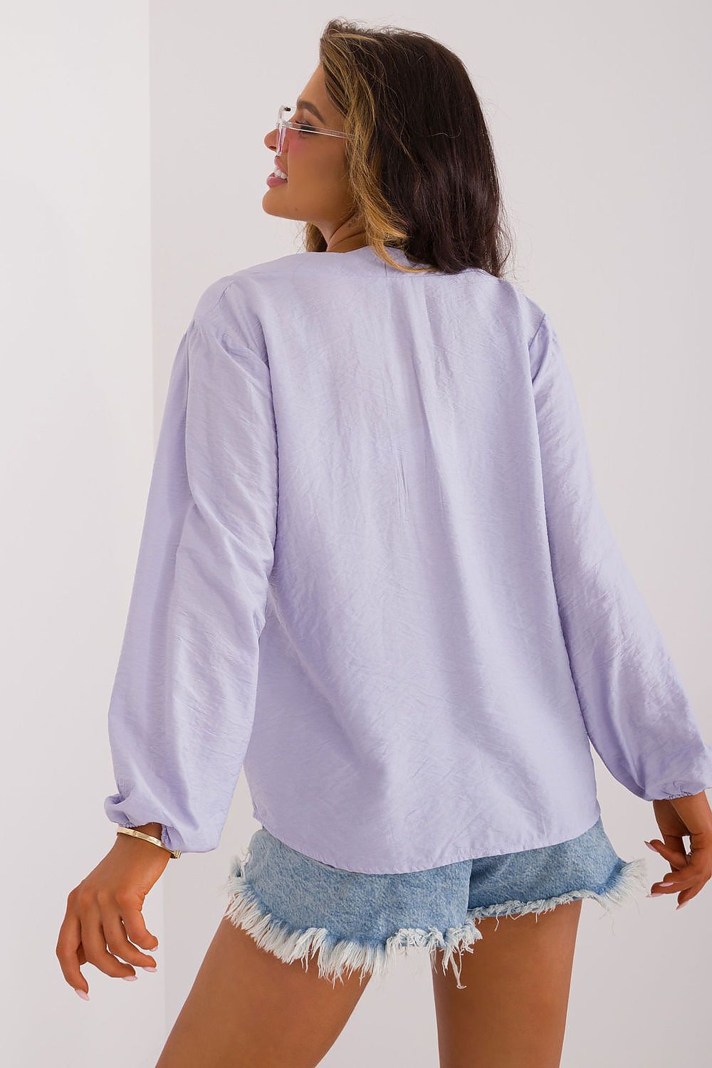 Model wearing Sublevel's elegant casual blouse with puffy sleeves and V-neck, paired stylishly with jeans for a chic look.