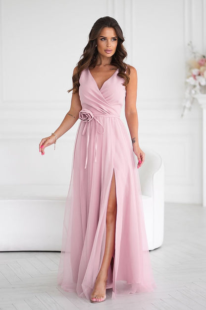 Stunning long dress by Bicotone featuring a sophisticated slit and elegant rose belt, perfect for formal occasions.
