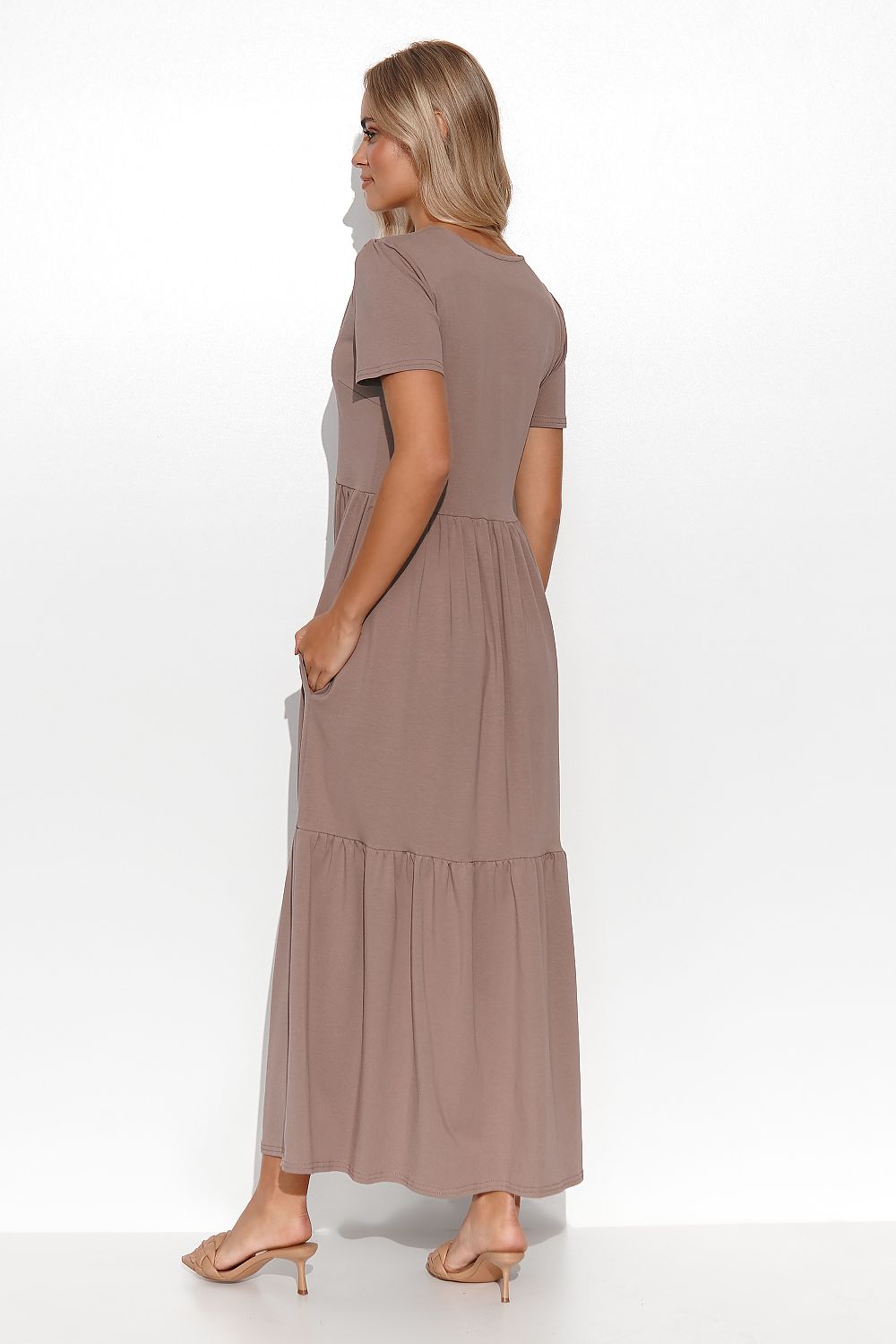 Elegant Makadamia Maxi Dress with Ruffles and V-Neckline, styled with accessories for a luxurious outfit.