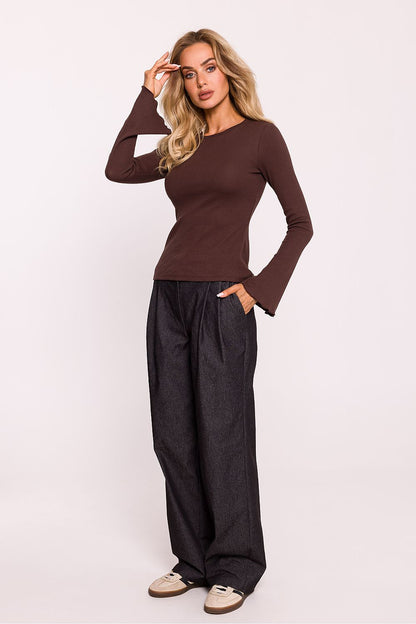 A luxurious ribbed cotton knit blouse by Moe displayed on a hanger, highlighting its elegant design and high-quality fabric.