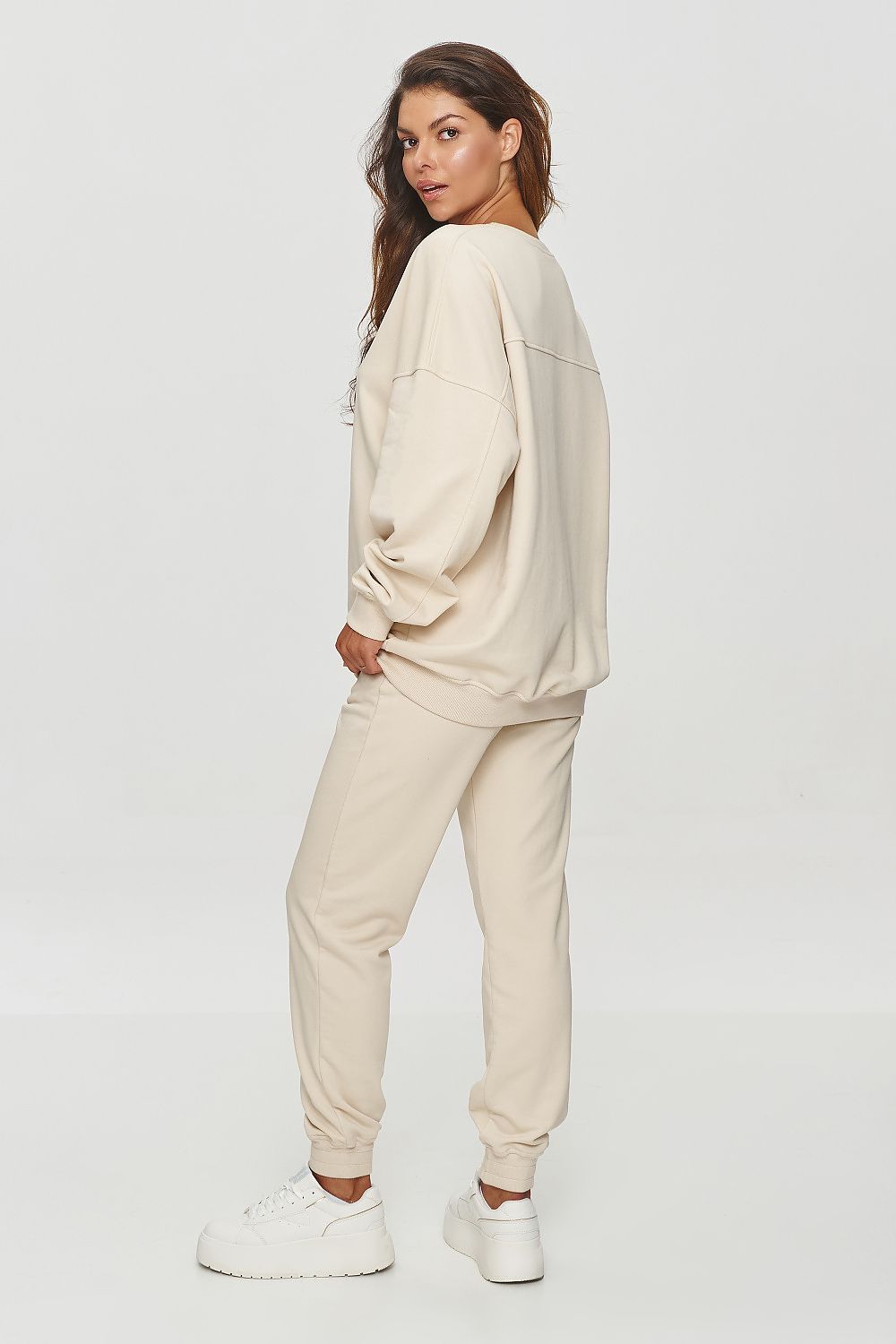 Stylish close-up of Makadamia tapered sweatshirt trousers showcasing the comfortable elastic waistband and sleek ankle cuffs, ideal for a chic casual look.